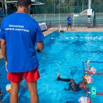 Enfants nageant à la piscine municipale sous la surveillance d’un éducateur d’aisance aquatique