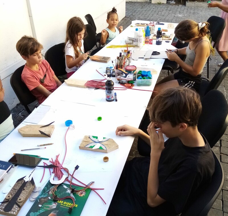 La Longère Sudel-FUMA accueille un atelier particulier ce mardi 16 mai 2023. Grâce à leur imagination, des marmay de Saint-Paul fabriquent des zoizos péi personnalisés. Matériaux de récupération, métal, plastique, bois : les enfants peaufinent leur réalisation avec l’aide de l’artiste, Claire MÉZAILLES, du duo Rdutemps formé avec Julien GAILLOT.