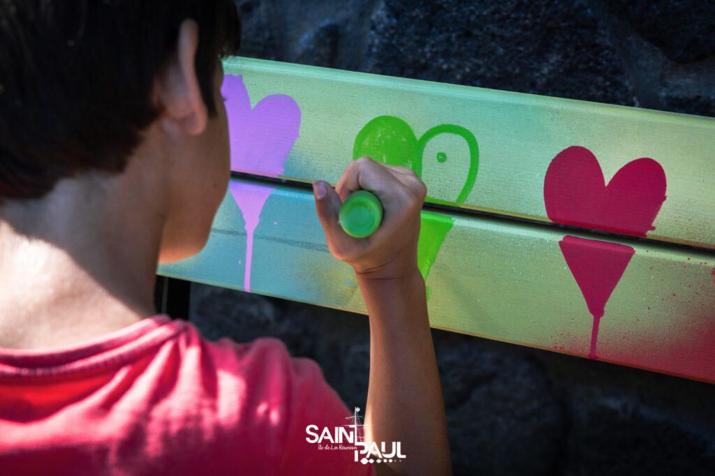 Un enfant dessinant un coeur sur le banc de l'amitié