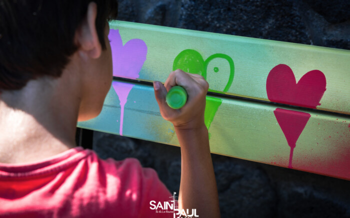 Un enfant dessinant un coeur sur le banc de l'amitié